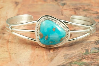 Genuine Castle Dome Turquoise set in Sterling Silver Bracelet. The Castle Dome Turquoise Mine is located about 30 miles from the Sleeping Beauty Mine, near Globe, Arizona. The Castle Dome Mine has not been in operation since the early 1970s. Created by Navajo Artist John Nelson. Signed by the artist.